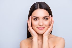 Woman with healthy skin holding her face